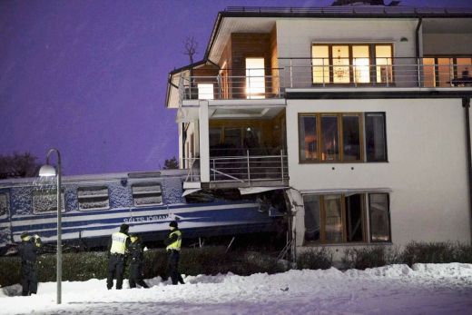 VILCIENA KATASTROFAS FOTO: Apkopēja nozog vilcienu un ietriecas dzīvojamā mājā